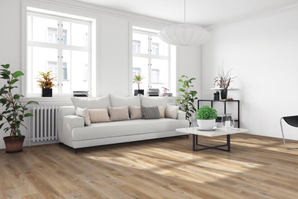 warm toned luxury vinyl plank flooring in living room with white couch and modern decor.